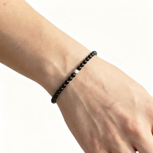 A woman wearing a 4mm Black Obsidian Elastic Beaded Energy Bracelet.