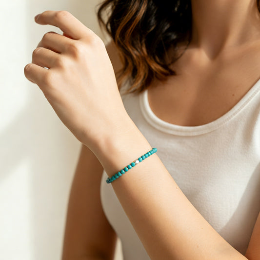 A woman wearing a 4mm Turquoise Elastic Beaded Energy Bracelet.