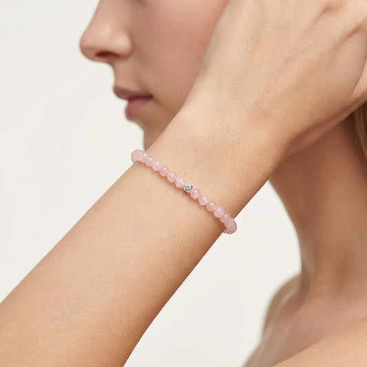 A woman wearing a 4mm Rose Quartz Elastic Beaded Energy Bracelet.