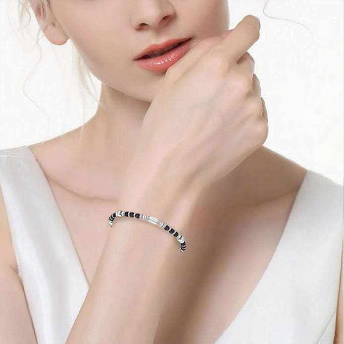A woman wearing an adjustable boho style Black Obsidian energy bracelet
