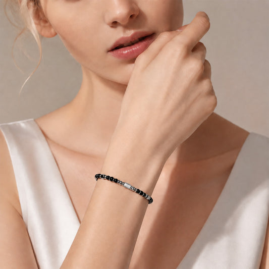 A woman wearing an adjustable boho style Black Obsidian energy bracelet