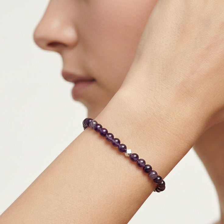 A woman wearing a 4mm Amethyst Elastic Beaded Energy Bracelet.