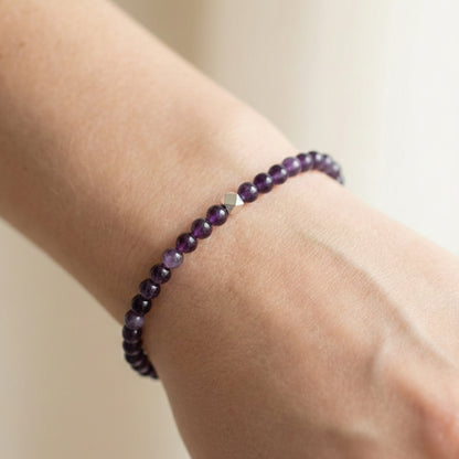 A woman wearing a 4mm Amethyst Elastic Beaded Energy Bracelet.