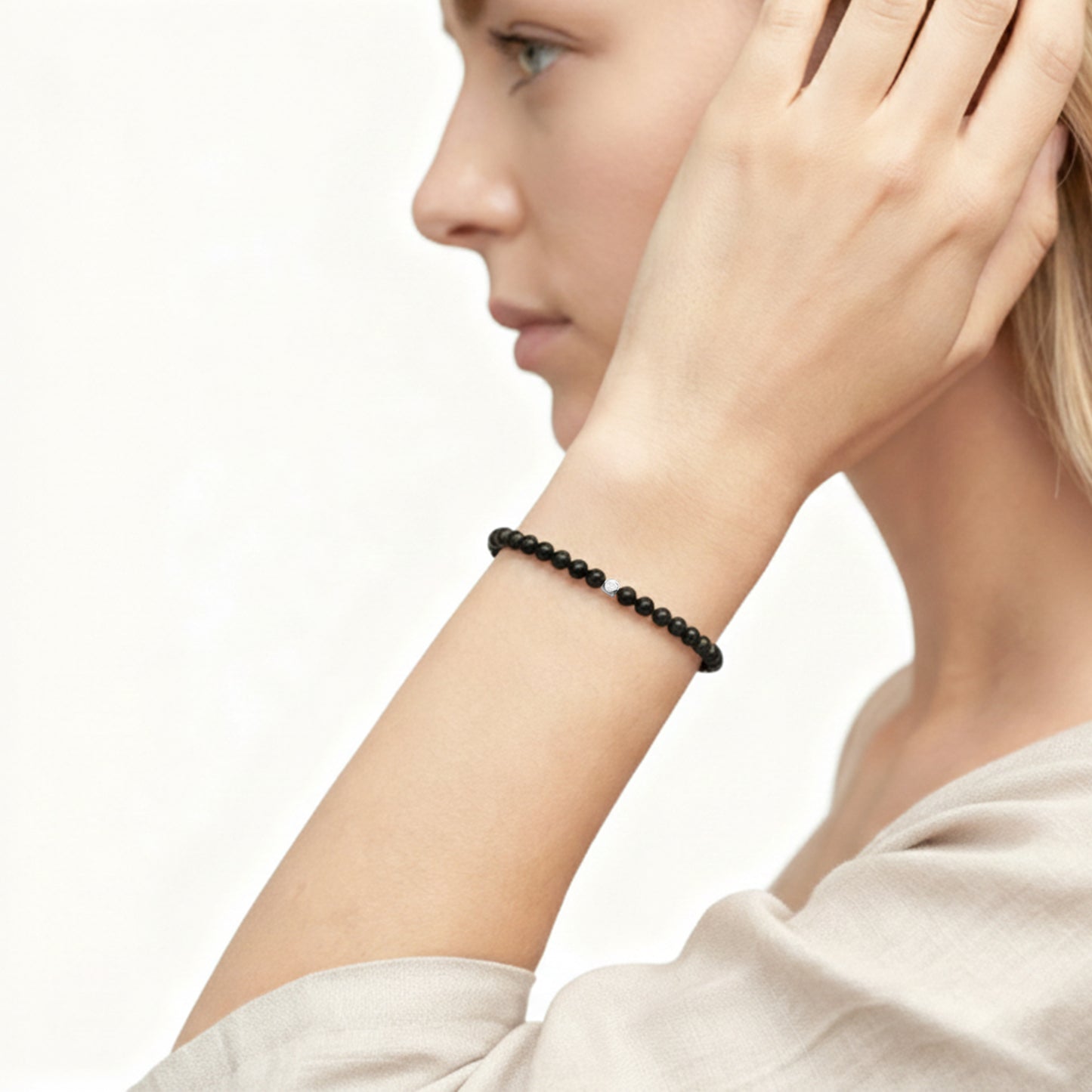 A woman wearing a 4mm Black Obsidian Elastic Beaded Energy Bracelet.