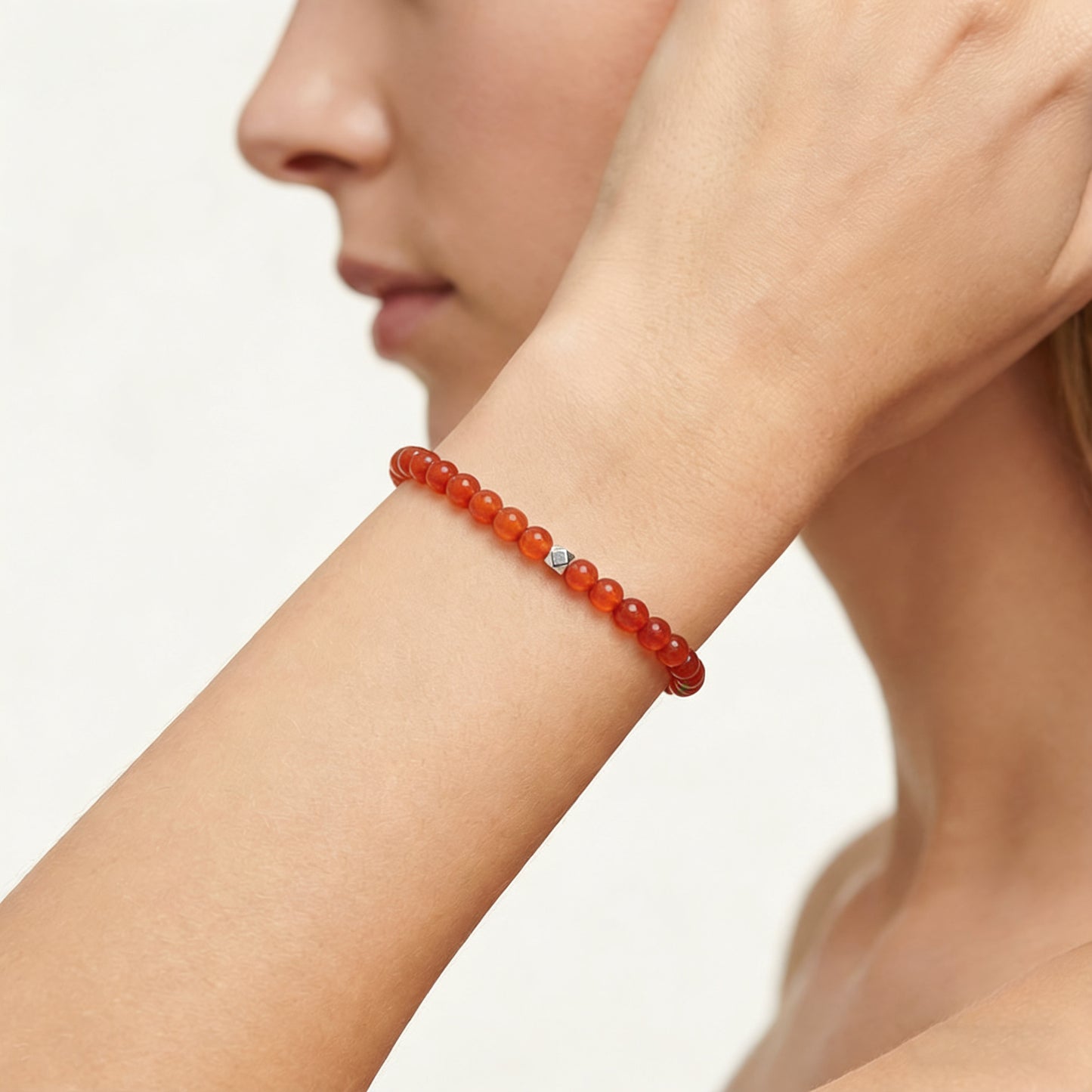 A woman wearing a 4mm Carnelian Elastic Beaded Energy Bracelet.
