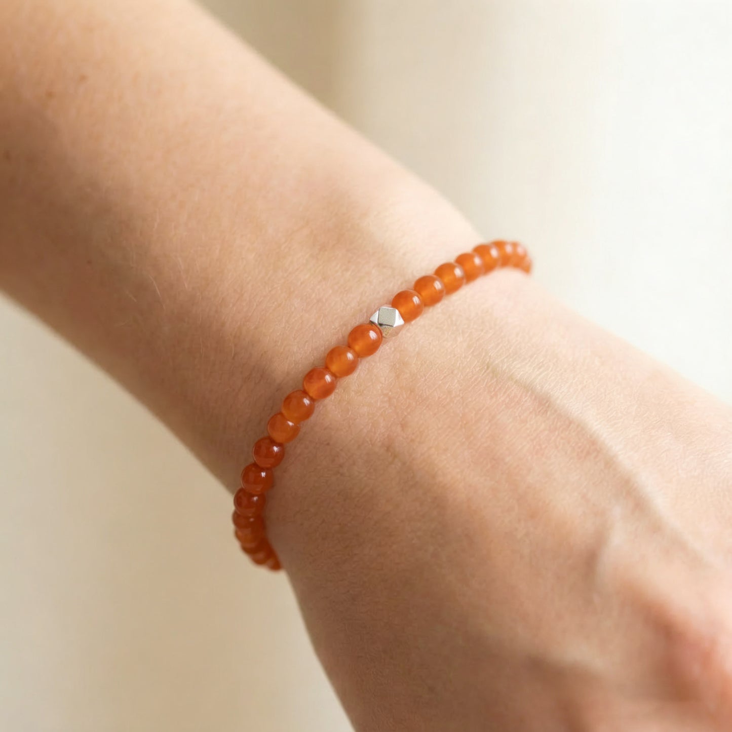 A woman wearing a 4mm Carnelian Elastic Beaded Energy Bracelet.