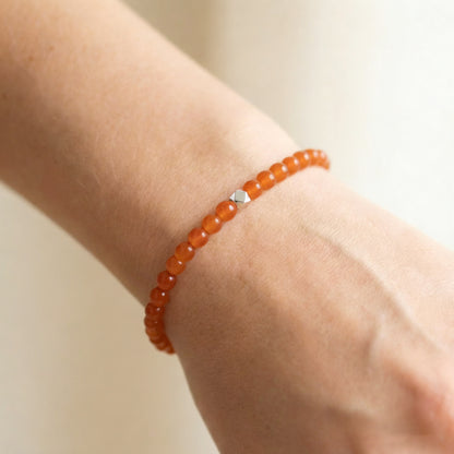 A woman wearing a 4mm Carnelian Elastic Beaded Energy Bracelet.