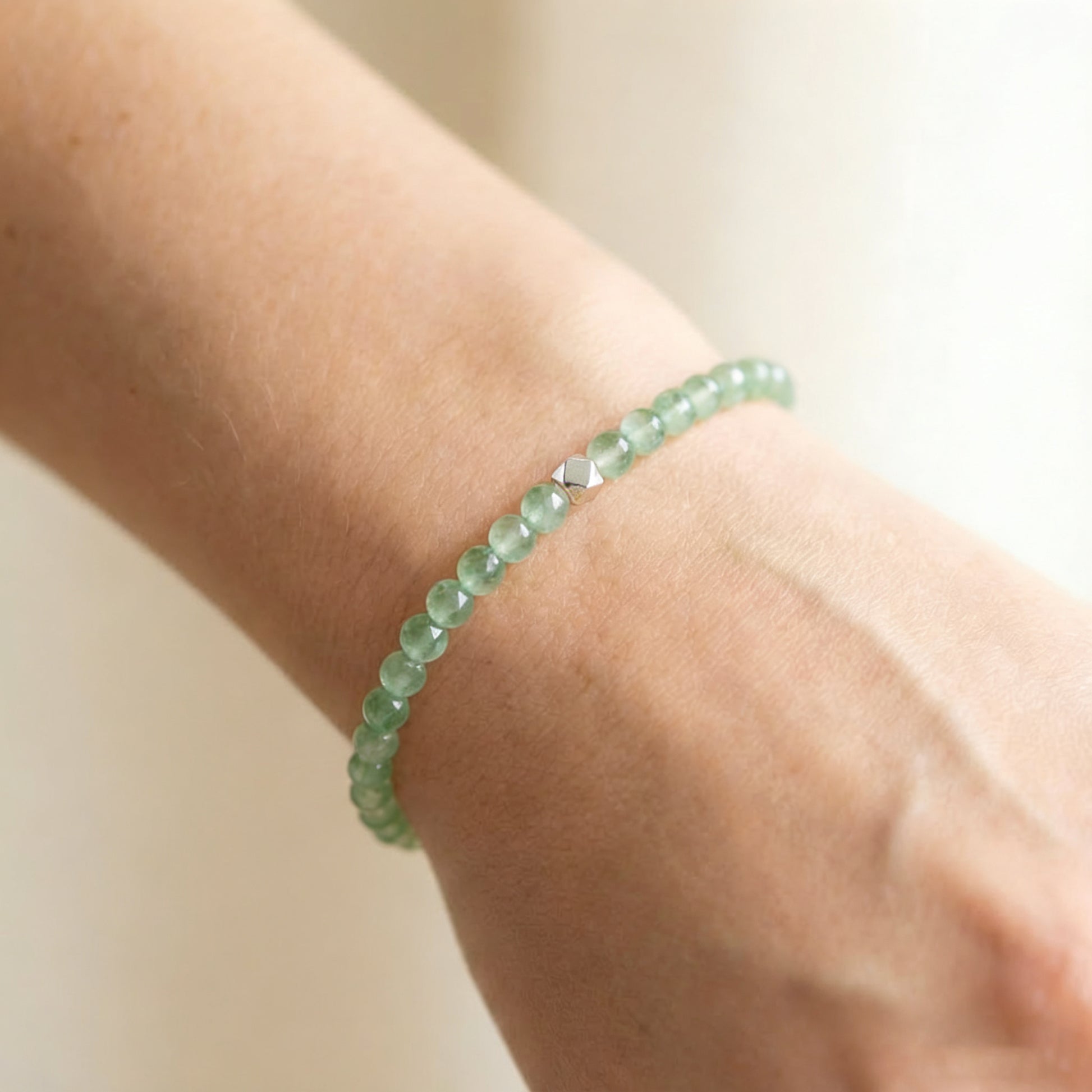 A woman wearing a 4mm Green Aventurine Elastic Beaded Energy Bracelet.