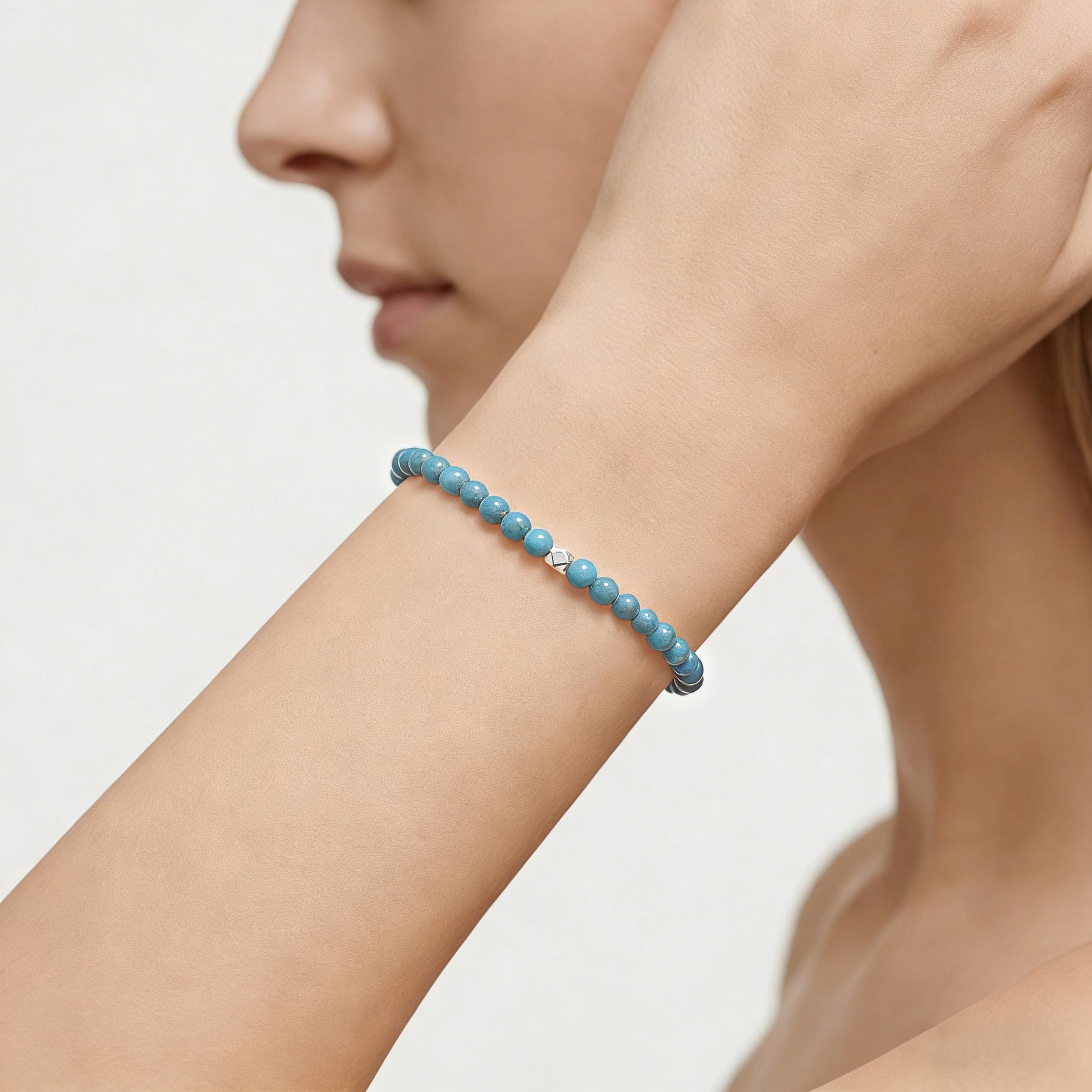 A woman wearing a 4mm Turquoise Elastic Beaded Energy Bracelet.