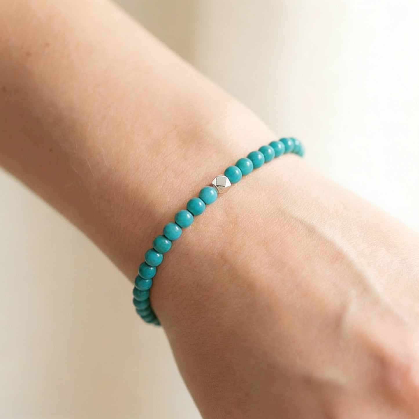 A woman wearing a 4mm Turquoise Elastic Beaded Energy Bracelet.