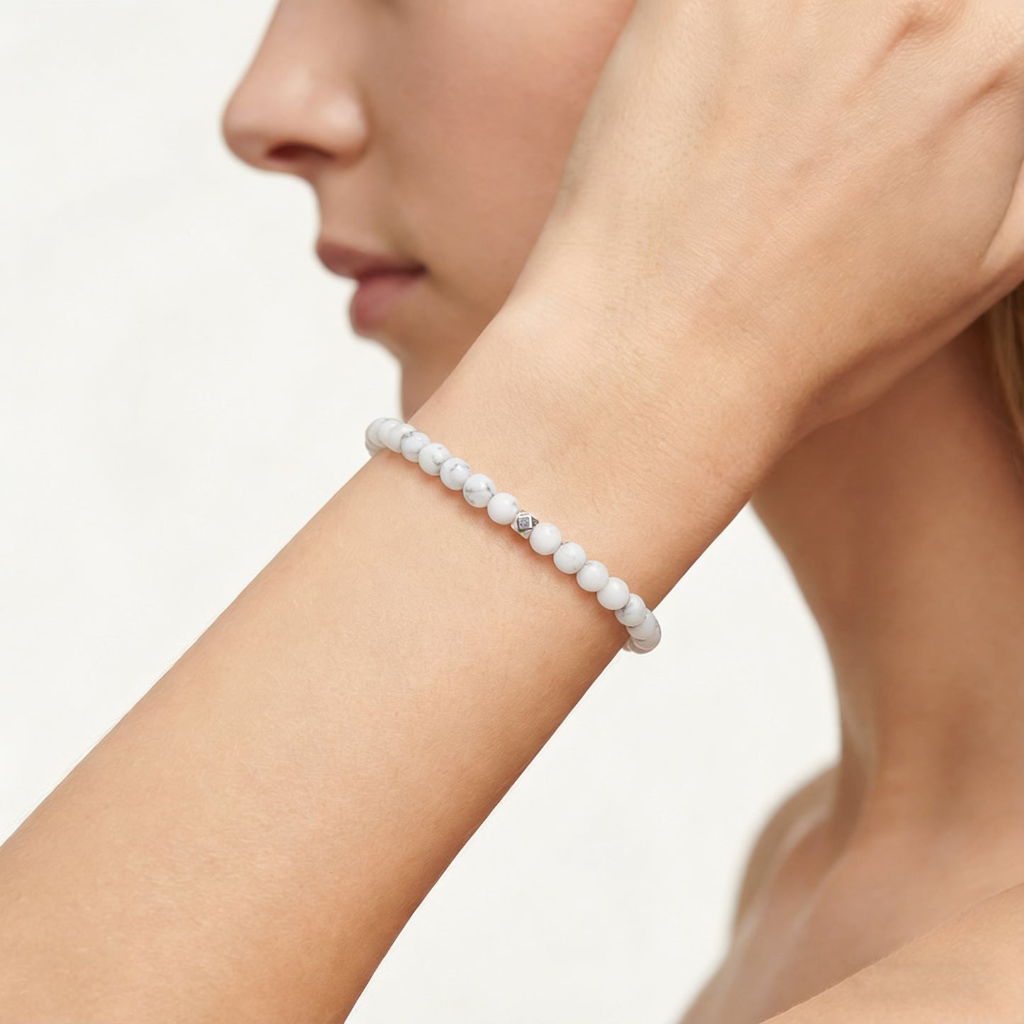 A woman wearing a 4mm Howlite Elastic Beaded Energy Bracelet.