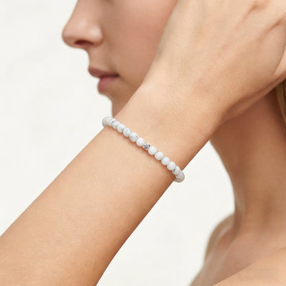 A woman wearing a 4mm Howlite Elastic Beaded Energy Bracelet.