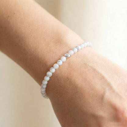 A woman wearing a 4mm Howlite Elastic Beaded Energy Bracelet.