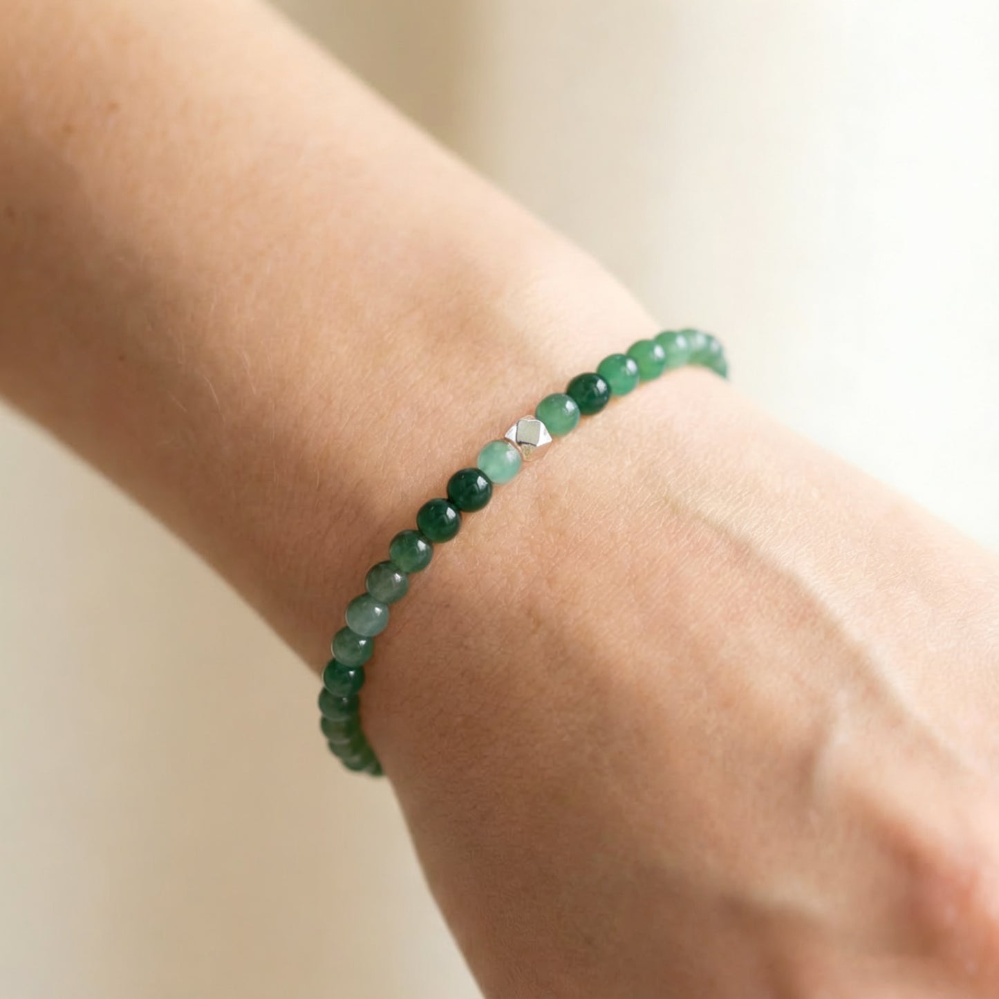 A woman wearing a 4mm Moss Agate Elastic Beaded Energy Bracelet.