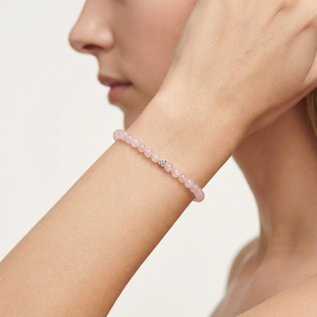 A woman wearing a 4mm Rose Quartz Elastic Beaded Energy Bracelet.