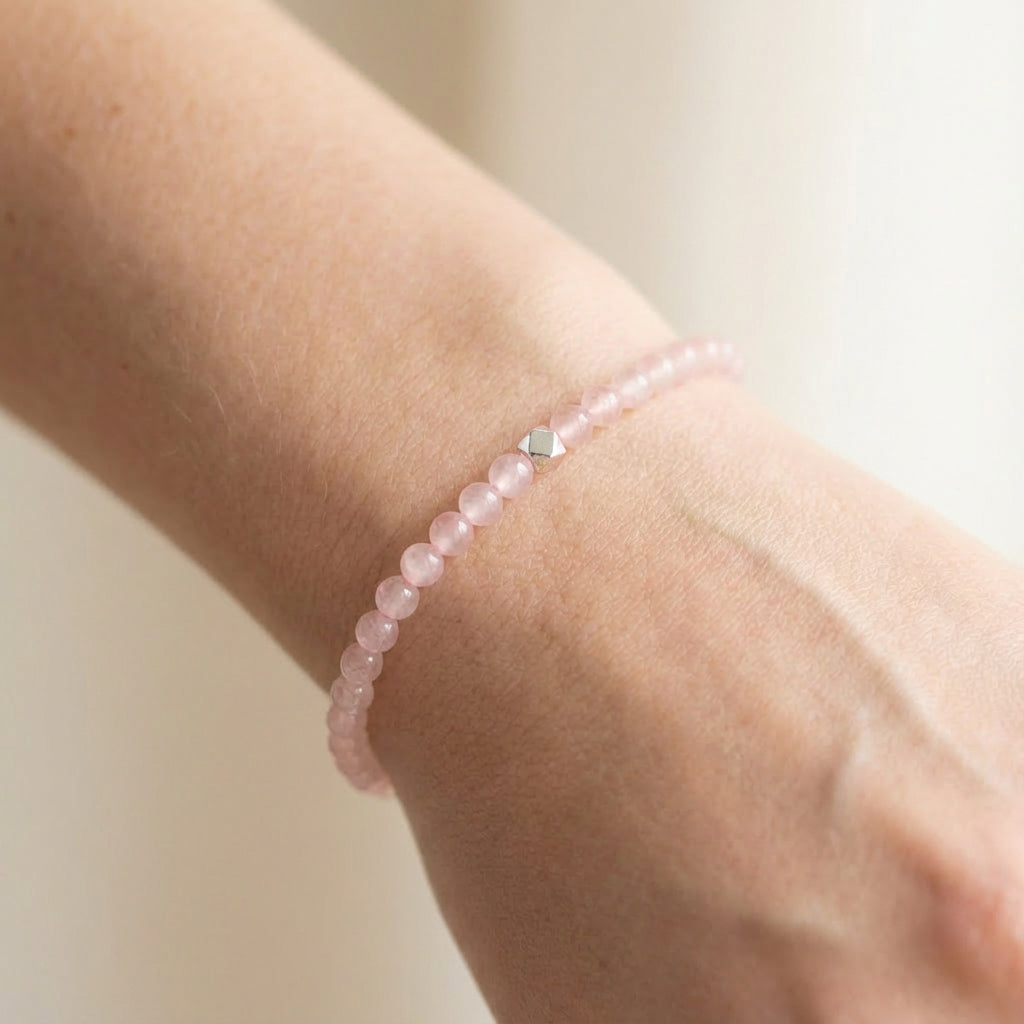 A woman wearing a 4mm Rose Quartz Elastic Beaded Energy Bracelet.