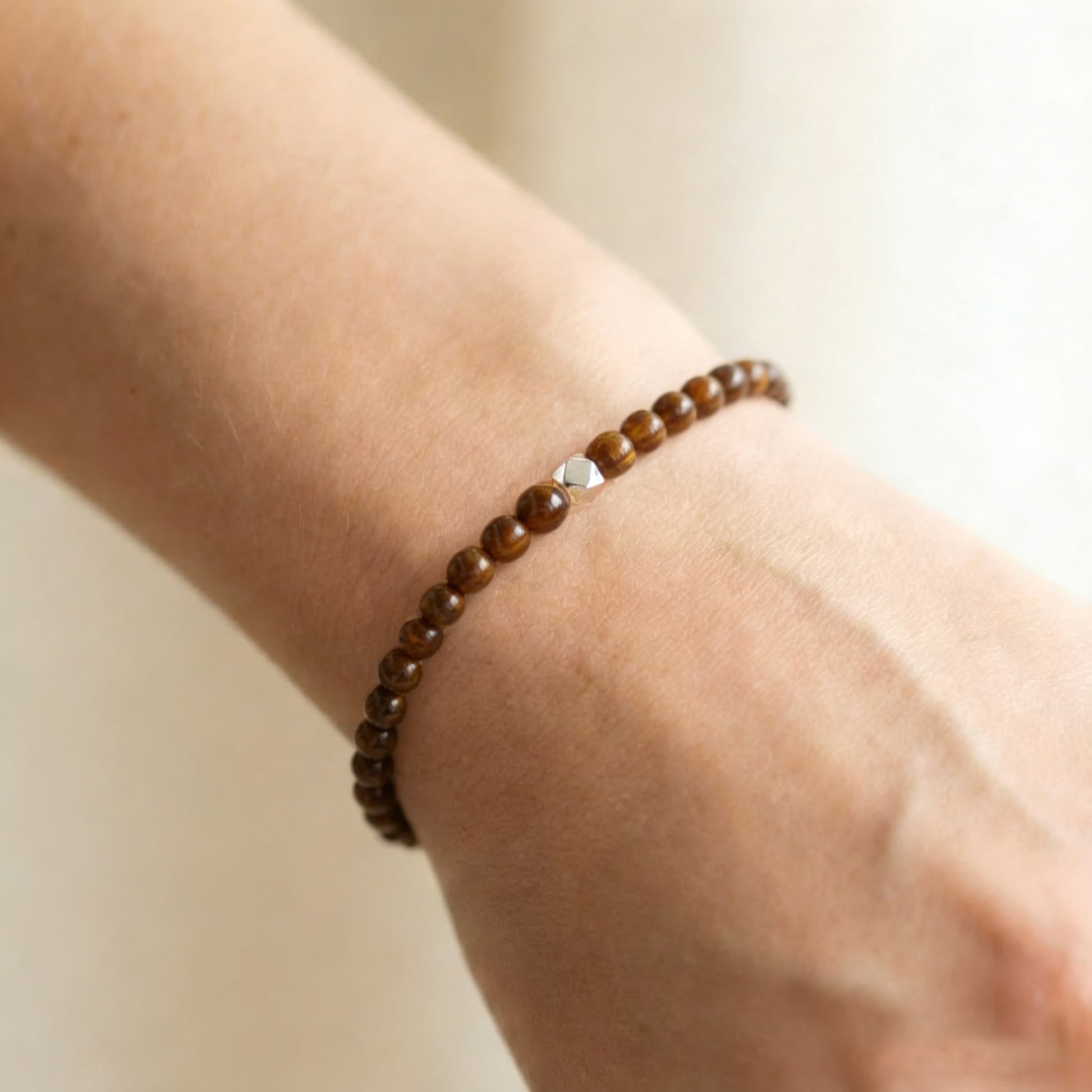 A woman wearing a 4mm Tiger's Eye Elastic Beaded Energy Bracelet.