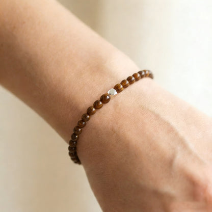 A woman wearing a 4mm Tiger's Eye Elastic Beaded Energy Bracelet.