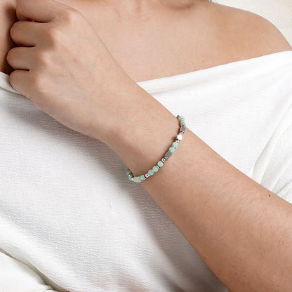 A woman wearing an adjustable boho style Amazonite energy bracelet.