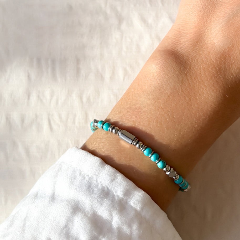 A woman wearing an adjustable boho style Greenish Turquoise energy bracelet.