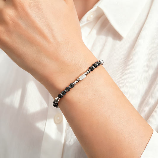 A woman wearing an adjustable boho style Lava Stone energy bracelet.