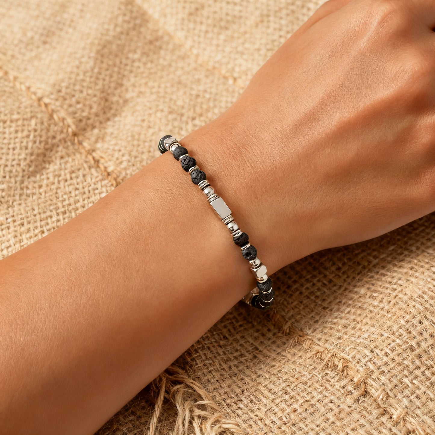 A woman wearing an adjustable boho style Lava Stone energy bracelet.