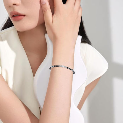 A woman wearing an adjustable boho style black obsidian bracelet