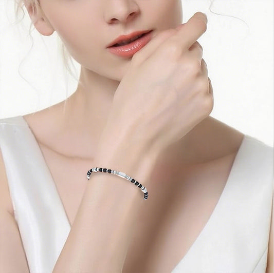 A woman wearing an adjustable boho style Black Obsidian energy bracelet
