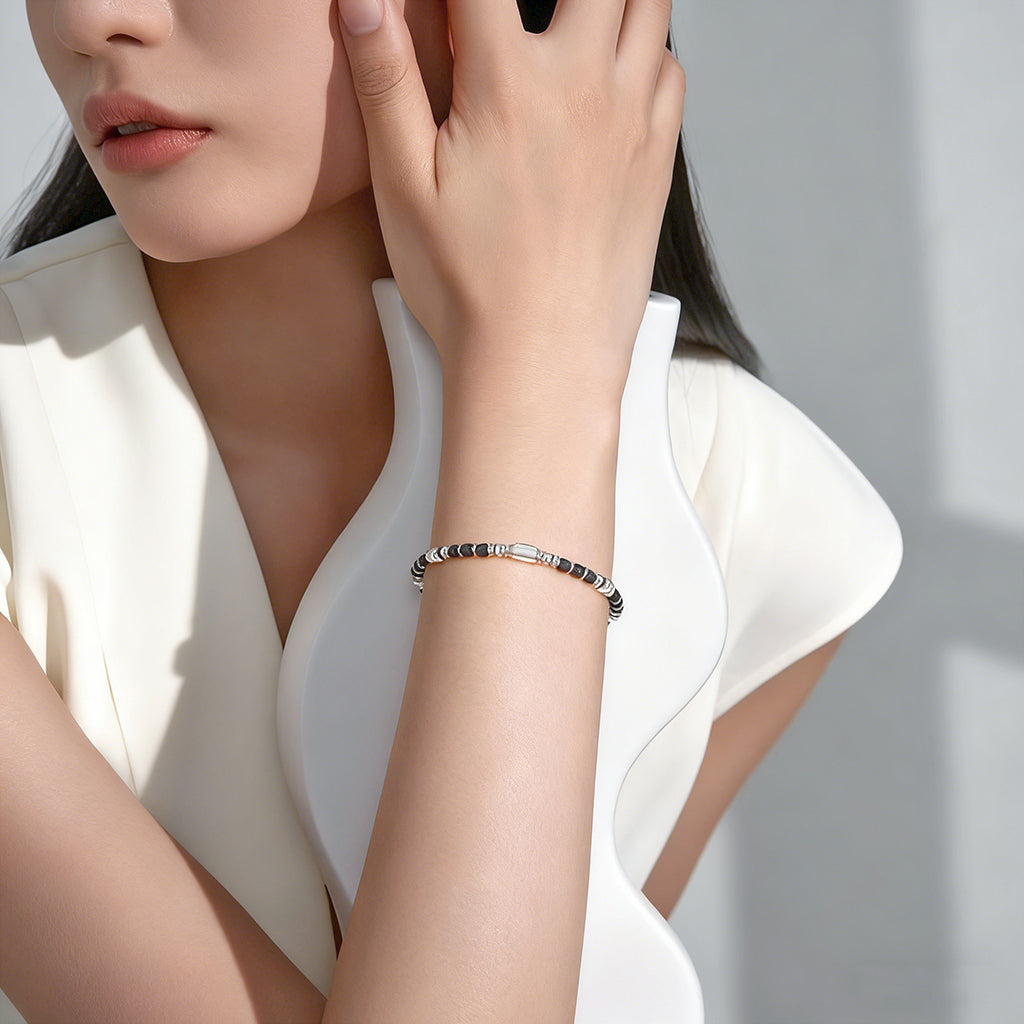 A woman wearing an adjustable boho style black obsidian bracelet