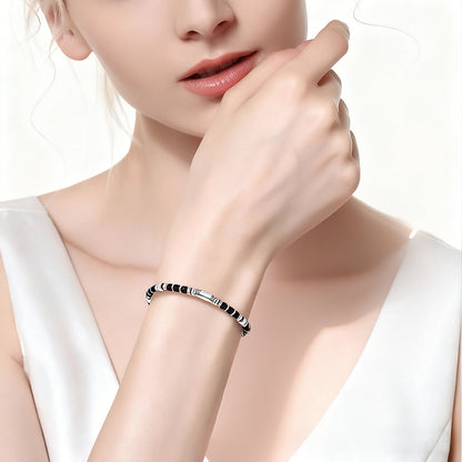 A woman wearing an adjustable boho style Black Obsidian energy bracelet