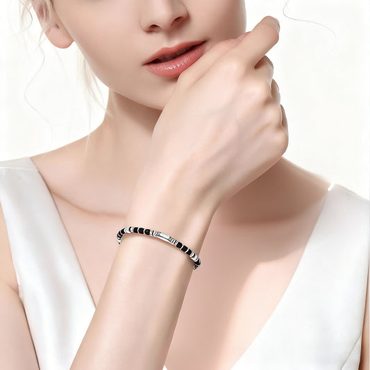 A woman wearing an adjustable boho style Black Obsidian energy bracelet