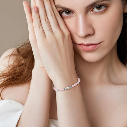A woman wearing an adjustable boho style rose quartz bracelet
