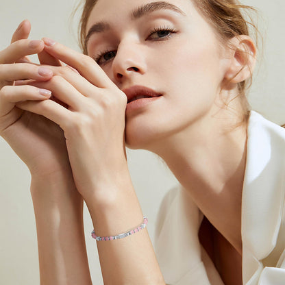 A woman wearing an adjustable boho style Rose Quartz energy bracelet