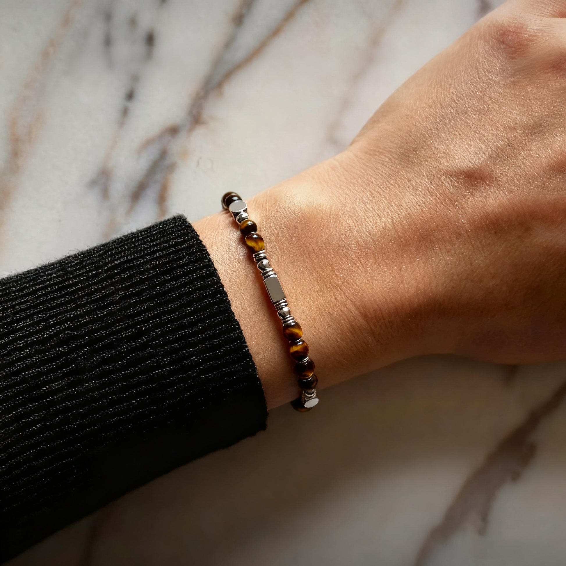 A woman wearing an adjustable boho style Tiger's Eye energy bracelet