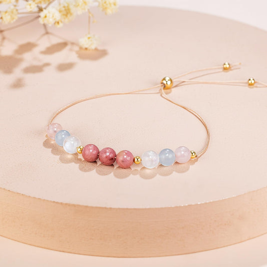 an adjustable beaded energy bracelet with rose quartz, aquamarine, moonstone and rhodonite.