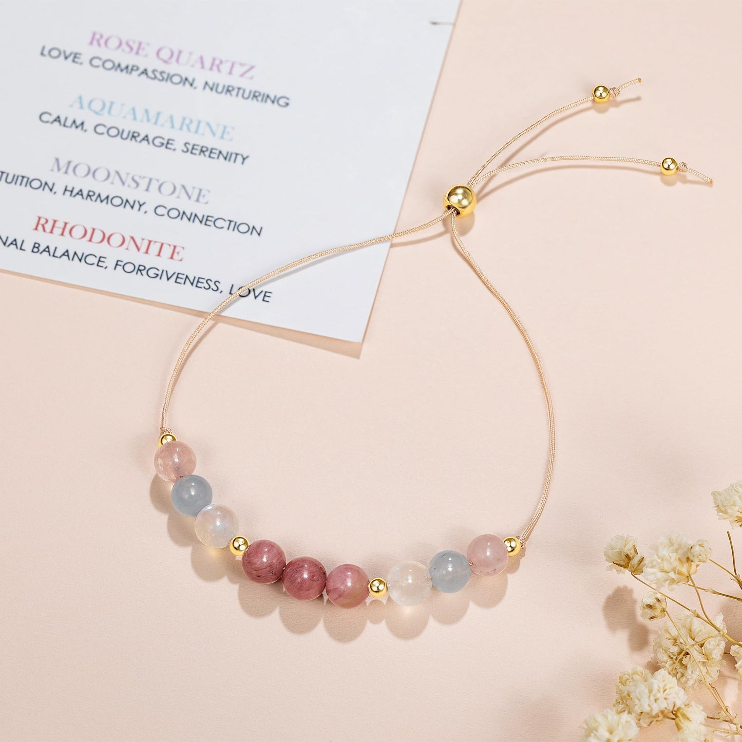 an adjustable beaded energy bracelet with rose quartz, aquamarine, moonstone and rhodonite.