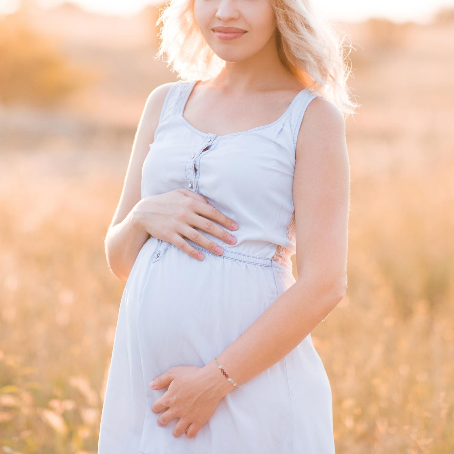 a pregnant woman wearing adjustable beaded energy bracelets with rose quartz, aquamarine, moonstone and rhodonite.