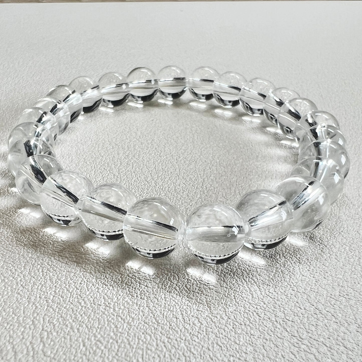 Detailed shot of a 8mm crystal bead bracelet with natural clear quartz texture.