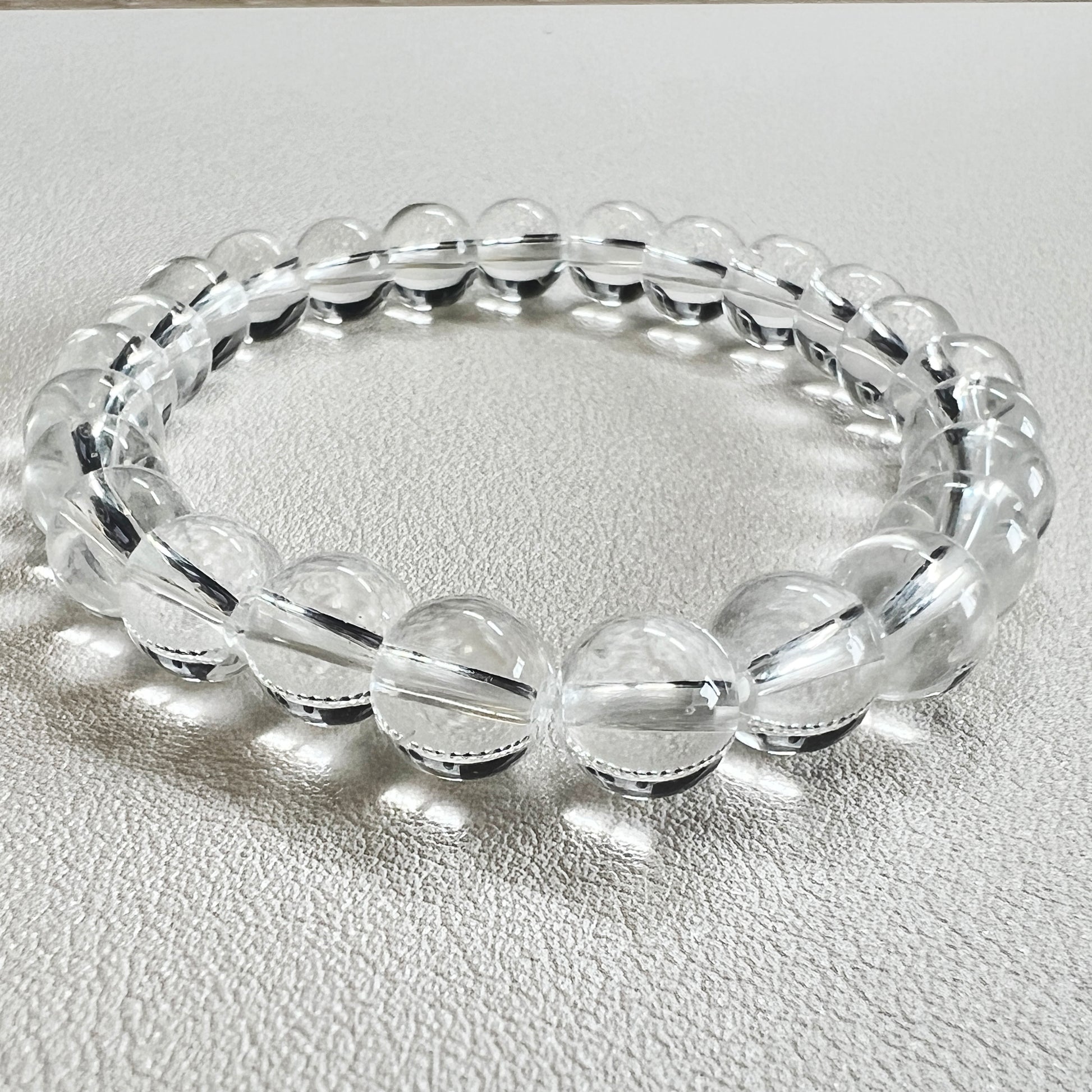 Detailed shot of a 8mm crystal bead bracelet with natural clear quartz texture.