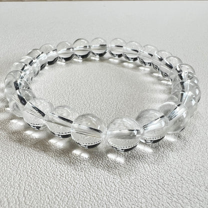 Detailed shot of a 8mm crystal bead bracelet with natural clear quartz texture.