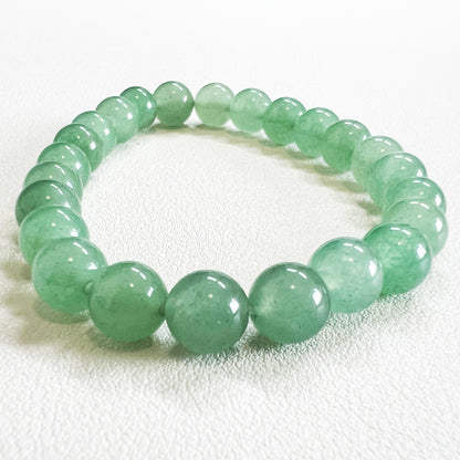 Detailed shot of a 8mm crystal bead bracelet with natural green aventurine texture.