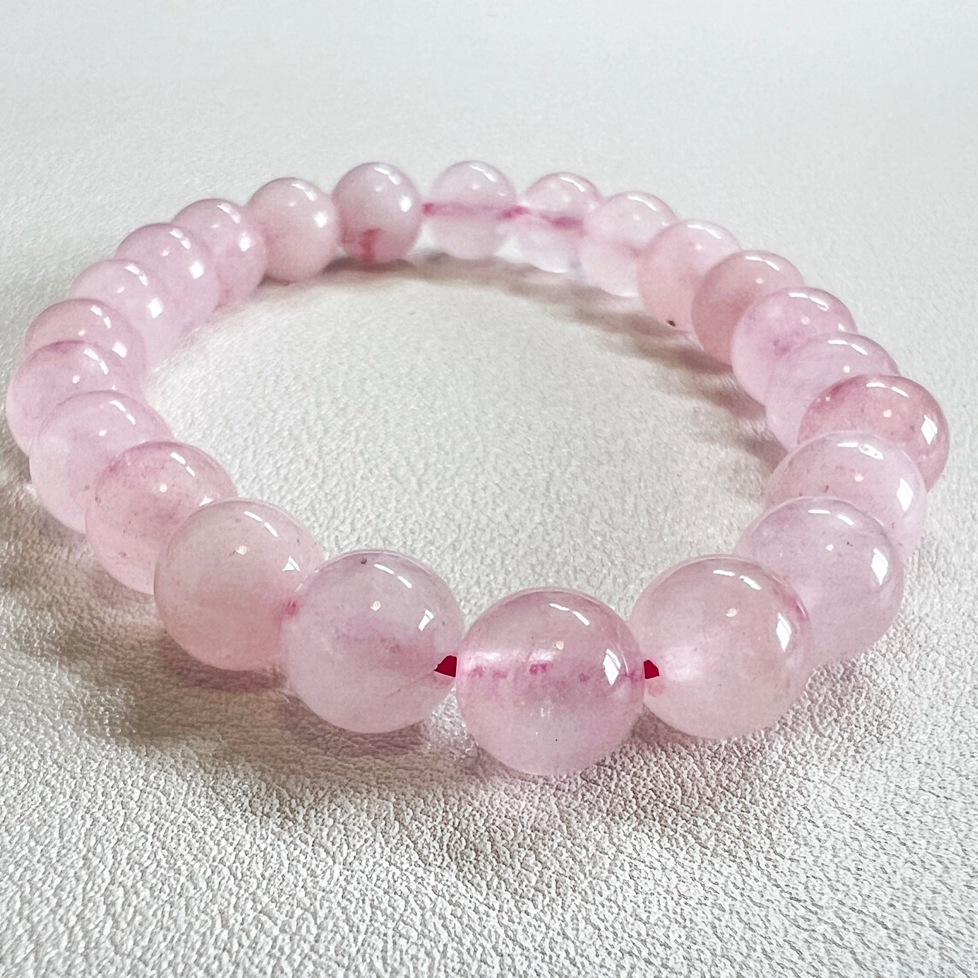 Detailed shot of a 8mm crystal bead bracelet with natural rose quartz texture.